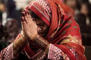 Sementara di Lahore, Pakistan, perempuan ini berdoa di altar.