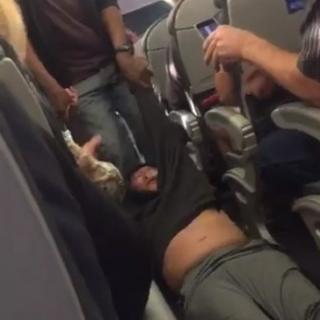 米ユナイテッド航空機内から航空治安当局に引きずりおろされる男性。乗客のジェイス・D・アンスパックさん撮影。