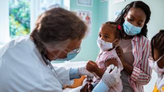 Child being vaccinated with mother