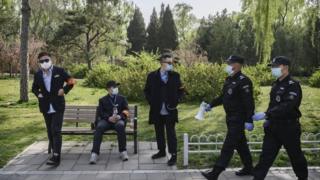 Китайские охранники и парковые рабочие 5 апреля в парке в Пекине