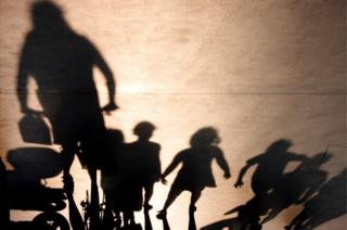 Shadowy adult with shadowy children