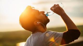 Hombre tomando agua de una botella