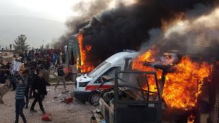 A smoke rises from vehicles after protesters stormed a Turkish military camp near Dohuk, Iraq