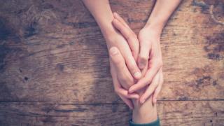 Un hombre y una mujer se dan la mano.