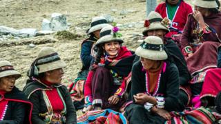 Mujeres vestidas con coloridos atuendos.