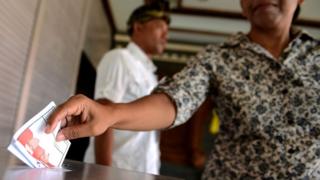 Балийская женщина баллотируется на избирательном участке в Куте на индонезийском курортном острове Бали 9 декабря 2015 года