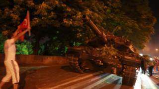 Tankı Türk bayrağıyla protesto eden bir kişi