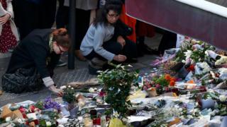 People in Paris leave flowers after the November attacks