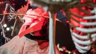 Plague doctor-style Halloween costume being worn in a parade