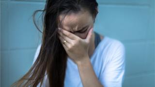 Woman covering face with hand