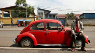 Siyum Haile, 72, wey bi retired United Nations (UN) employee and Jehovah's Witness, pose for photograph beside im 1977 model Volkswagen Beetle car for Addis Ababa, Ethiopia - 16 September 2017 - photo published 27 October 2017