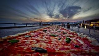 The pizza laid out along the seafront in the Italian city if Naples.