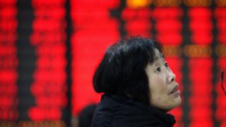 A woman watches the electric monitor during a stock exchange in Huaibei on March 9, 2015