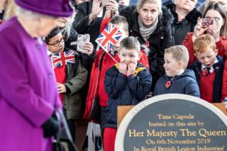 Children react as Queen Elizabeth II arrives to bury a time capsule at the Royal British Legion Industries Vllage in Aylesford