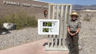 Brandi Stewart poses in front of a temperature reading of 130F