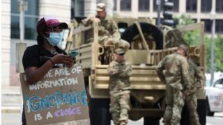 National Guardsmen watch on as a protester demonstrates in Washington DC