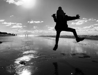 The silhouette of a girl jumping on a beach