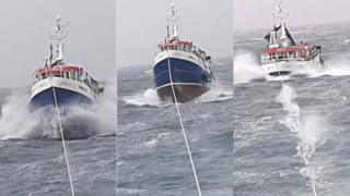 Fishing boat under tow in rough conditions