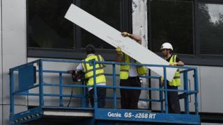 Рабочие снимают облицовку для испытаний с одного из башенных блоков в Солфорде