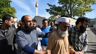 Члены мусульманской общины реагируют, когда они покидают мечеть Аль-Нур в Крайстчерче