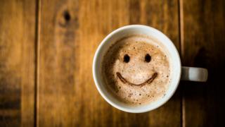 Кофейная чашка с улыбающимся лицом