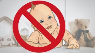 A baby with a cross through it