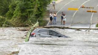 A car is submerged in flood waters on a road near Bega in NSW