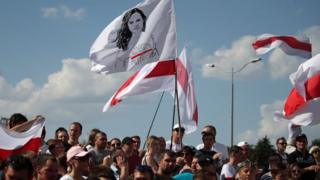 Belarus opposition activists hold a flag with a portrait of opposition leader Svetlana Tikhanovskaya