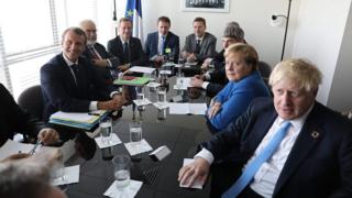 French President Emmanuel Macron (L) meets with German Chancellor Angela Merkel and British Prime Minister Boris Johnson (R) at the UN headquarters on Sept 23, 2019, in New York