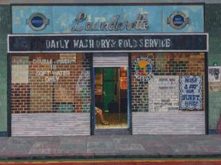 A painting of the front of a launderette with a woman sitting inside the doorway by Doreen Fletcher