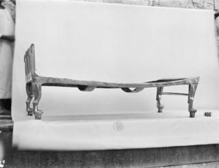 Two Egyptian boys holding up the backdrop behind the bed artefact