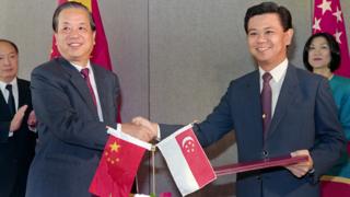 錢其琛(左)與新加坡外長黃根成(右)簽署中新建交協議後握手(3/10/1990)