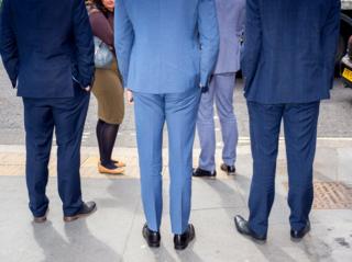 Men in suits wait to cross the road. St Paul's, London.