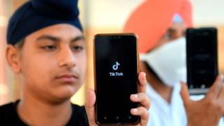 Indian boy with TikTok app opened on phone.