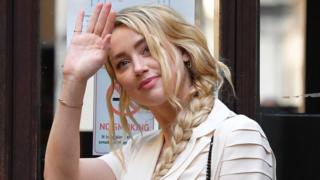 US actress Amber Heard waves as she arrives on day 10 of the libel case brought by ex-husband Johnny Depp