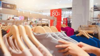 Shopper looks through sale rack