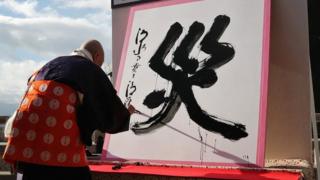 The kanji character for "disaster", written on a white placard