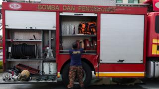 A firefighter moves hose after fighting with blaze in Kuala Lumpur, Malaysia