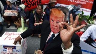 Учасник акції протесту у масці Трампа