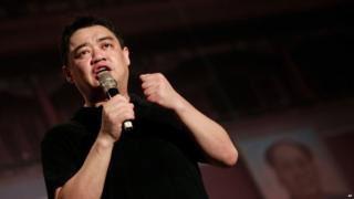 Former student leader in the protests of 1989, Wuer Kaixi, speaks in front of a mock Tiananmen Square backdrop