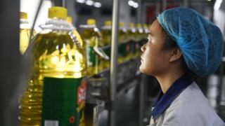 This photo taken on July 19, 2018 shows a worker monitoring a soybean oil production line at the Hopeful Grain and Oil Group factory in Sanhe, in China's northern Hebei province.