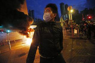 Дым поднимается, когда протестующие поджигают улицу в районе Монг Кок в Гонконге, во вторник, 9 февраля 2016 года.
