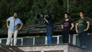 Image shows Parisa Pourtaherian taking photographs of the game