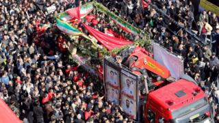A lorry carrying the coffins of Iranian firemen who were killed in the Plasco building collapse is surrounded by mourners in Tehran (30 January 2017)