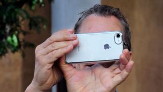 Hombre tomando foto con un iPhone