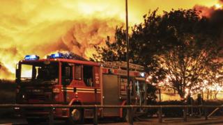 Fire fighters in the West Midlands tackle a major blaze. Fire engine in the foreground.