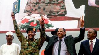 Ahmad Rabie (à droite), l'un des leaders des manifestations pro-démocratie, aux côtés du général Abdel Fattah al-Burhan, le chef du Conseil militaire de transition, lors de la signature du nouvel accord de partage du pouvoir, samedi 17 août, à Khartoum.