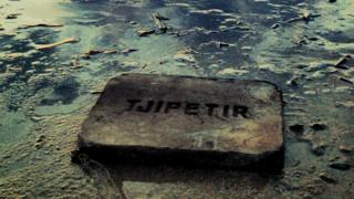 A rubber block engraved with the words Tjipetir washed up on a beach
