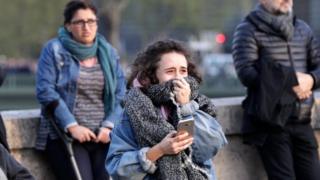 Seorang perempuan terisak menyaksikan Notre Dame terbakar di depan matanya