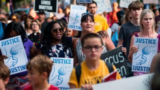 A march in Minneapolis in 2017 with protesters holding placards saying 